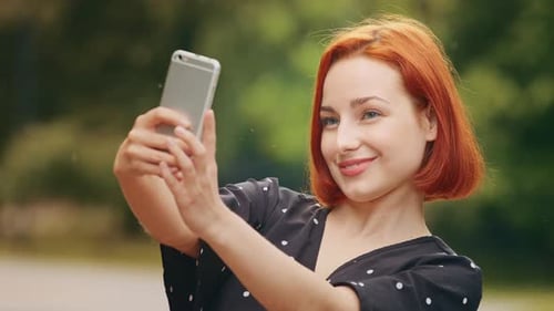 Auburn Haired Woman Takes Selfie Outdoors