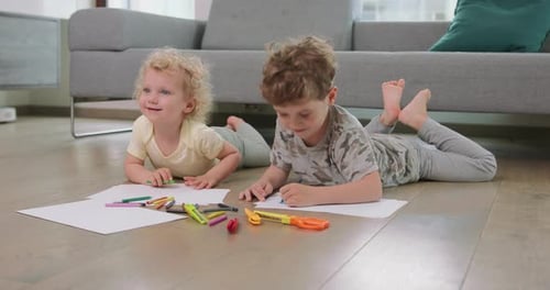 Children Drawing Together on the Floor Indoors