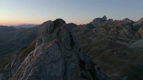 Aerial Epic Shot of a Man Standing on the Edge of the Mountain