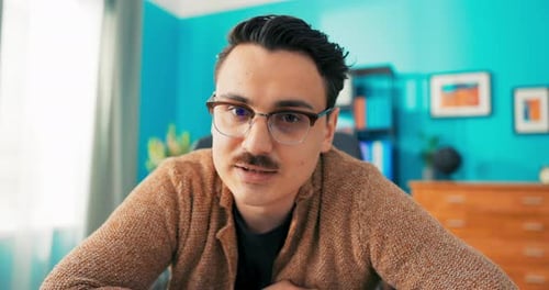 Man Wearing Glasses Talking Indoors in Front of Camera