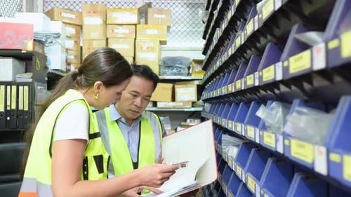 Responsable d'entrepôt et employée d'entrepôt comptant les petites pièces stockées