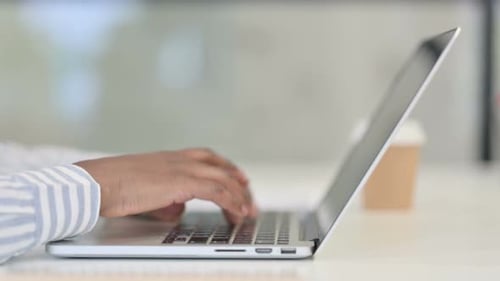Close Up of African Man Typing on Laptop