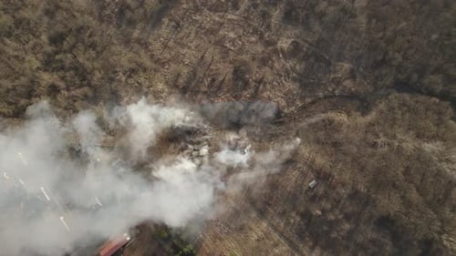 Aerial top-down orbit over the wildfire of dry meadow and forest due to the long-lasting drought