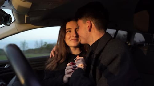 Affectionate Young Couple Embracing in a Car