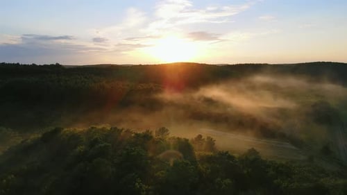The Sun's Rays Illuminate a Light Fog That Descends on the Forest Hills