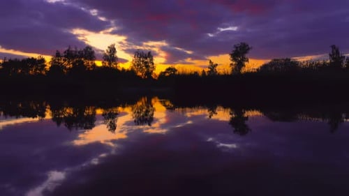 Colorful Sunset Reflected on Still Lake Water