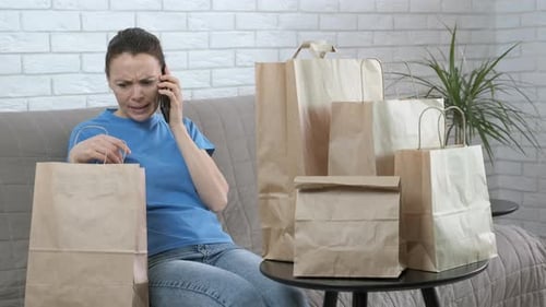 Annoyed Woman On Phone With Delivery Paper Bags