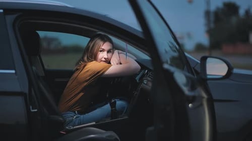 Thoughtful Young Woman Sitting in Car at Night