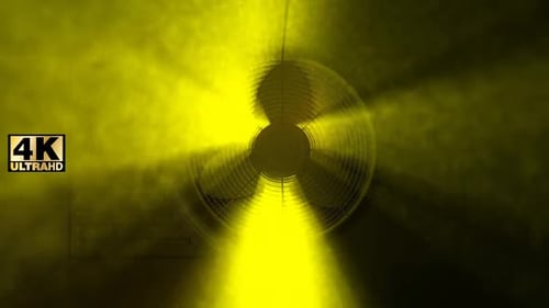 Rotating Industrial Fan with Vibrant Yellow Light Beams and Smoke