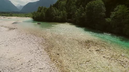 Luftaufnahme einer Gruppe von Menschen beim Rafting im türkisblauen Wasser am Fluss Soca.
