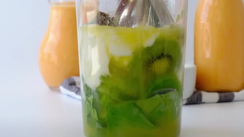 Woman Cooking Healthy Smoothie Add Green Apple Kiwi Spinach Blended in Blender Green Smoothies