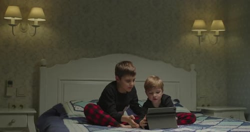 Siblings Use Tablet Computer for Bedtime Movie
