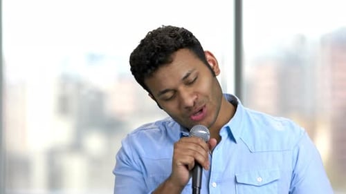 Young Adult Male Speaking Into Microphone