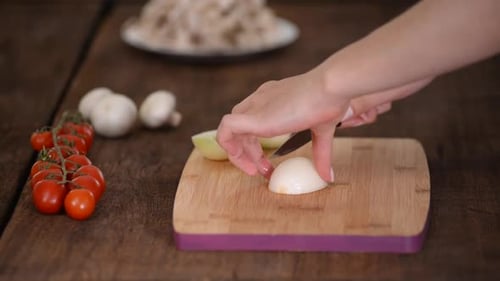 Hands Slicing an Onion in Kitchen Environment
