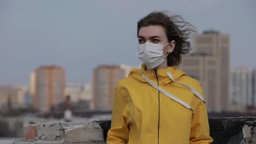 Covid-19 Virus Epidemic, Woman Wearing Surgical Mask on the Roof of City