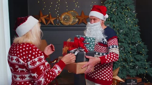 Senior Couple Exchanging Christmas Gifts at Home