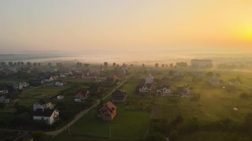 Aerial View Foggy Sunrise Over Residential Houses in Suburban Rural Area