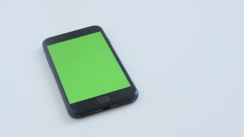 Modern black wireless tablet with green screen display slow tilt 4K 2160p 30fps UltraHD footage -