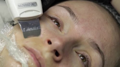 Cosmetologist Make Ultrasonic Face Cleaning on Woman Face in Beauty Clinic Salon