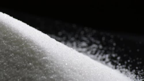 Weiße Zuckerkörner kreisend