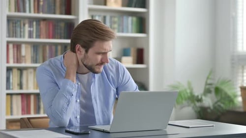 Man Working on Laptop, Rubbing Stiff Neck