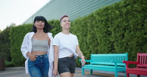 Two Lesbian Women Walking on the Street Hugging Each Other Talking and Smiling