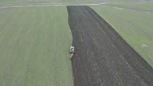 Tractor Tilling Soil in a Rural Farm Field
