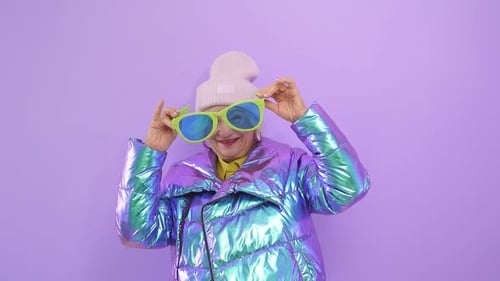 Fashionable Senior Woman Posing With Green Sunglasses