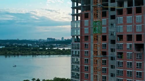 Vuelo vertical aéreo a lo largo de la construcción de un edificio de varios pisos