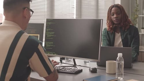 Diverse Programmierer, die im Büro Programmcodes auf dem Computer eingeben