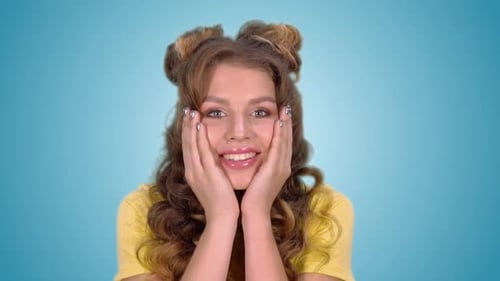 Excited Woman With Curly Hair Smiles in Studio