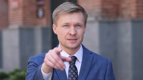 Man in Suit Invites with Hand Gestures
