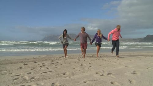 LS OF FRIENDS RUNNING ALONG A BEACH