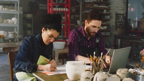 Artists Sketching Designs in Bright Workshop