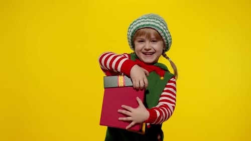 Smiling Child Opens a Christmas Gift