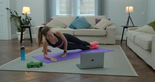 Fit and Healthy Woman in Sportswear Doing Exercises with Help of Her Instructor Online on Laptop at