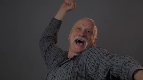 El viejo expresa emociones felices, grita y levanta los brazos