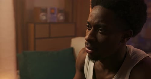 Closeup Portrait of an Athletic Man in a White Tshirt Relaxing After Work Playing on Console He is