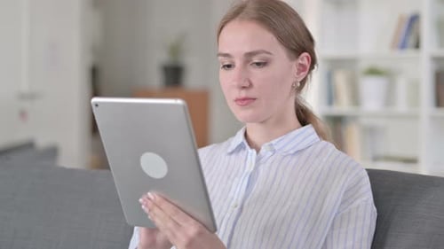 Young Woman Using Tablet Device at Home