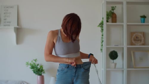 Woman Showing Off Weight Loss in Old Jeans