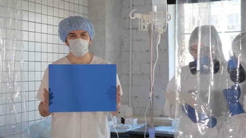 Patient holding blank board and Doctors in the protective