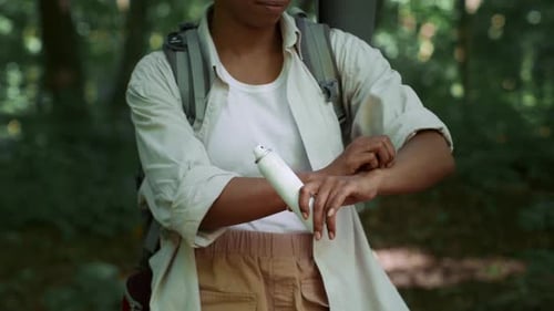 Hiker Spraying Insect Repellent in Forest