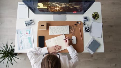 Geschäftsfrau arbeitet am PC und macht sich Notizen