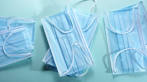 Light Blue Surgical Masks on Blue Background