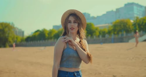 Happy Girl Walking on the Beach in the Early Morning. Beautiful Woman in a Hat Is Resting By the Sea