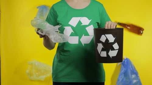 Una mujer irreconocible puso un paquete de celofán en un basurero. Salva la ecología. Contaminación natural plástica