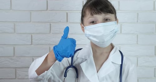 Young Child Doctor Gives Thumbs-Up with Mask