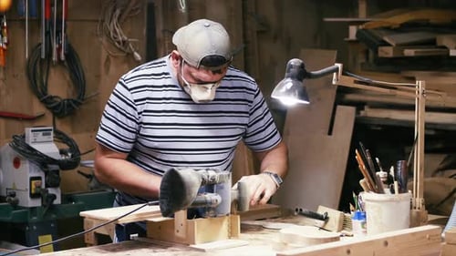 Craftsman Working with Grinding Machine at Wood Workshop.