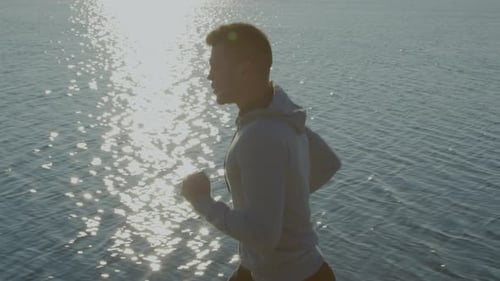 Man Runner Is Jogging Near Lake