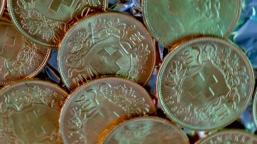 Close up spinning shot showing many rarely golden vreneli gold coins of swiss franc.